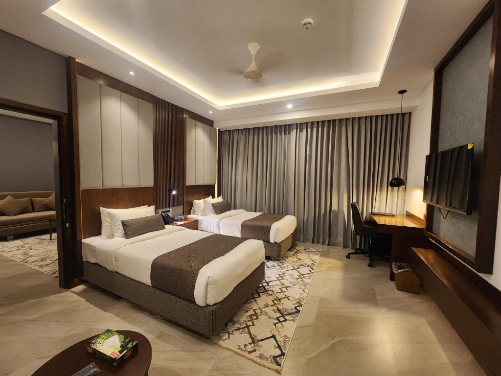 ein Hotelzimmer mit 2 Betten und einem TV in der Unterkunft Hotel Windy Terrace in Cox's Bazar