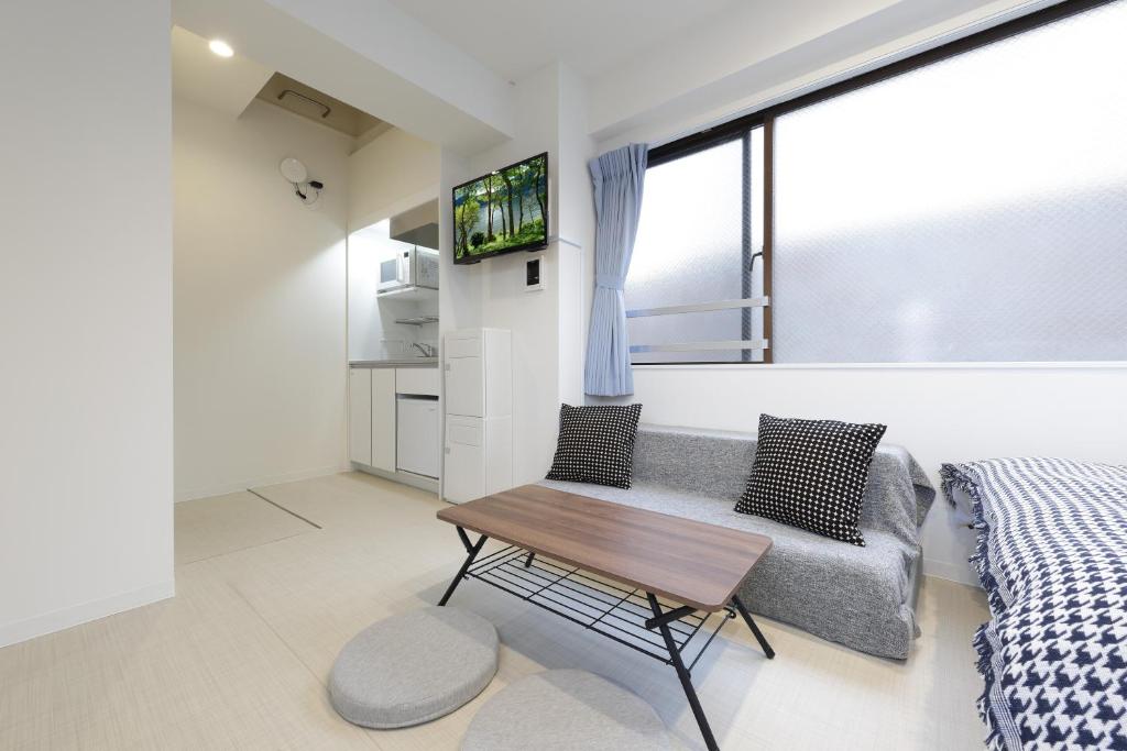 a bedroom with a couch and a table and a tv at IKEBUKURO MANGA HOUSE in Tokyo