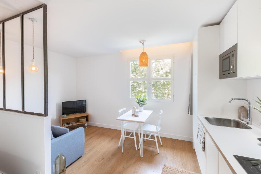 a kitchen and dining room with a table and a blue couch at Les appartements de Montpellier in Montpellier