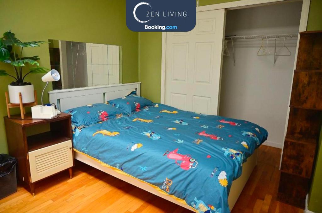 a bed with a blue comforter with fish on it at # 2 Charming Queen Bed - Shared Room - Business Travel! By Zen Living Short Term Rental in Brooklyn