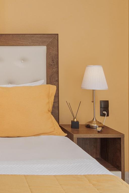 a bedroom with a bed and a table with a lamp at Costa Smeralda in Syvota