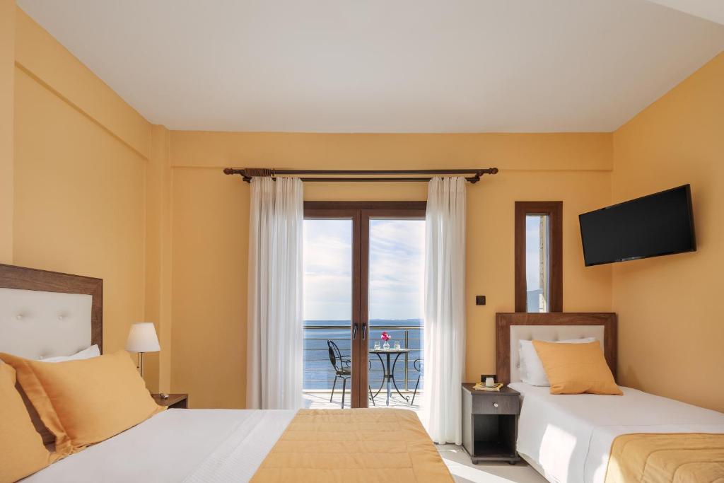a bedroom with two beds and a view of the ocean at Costa Smeralda in Syvota