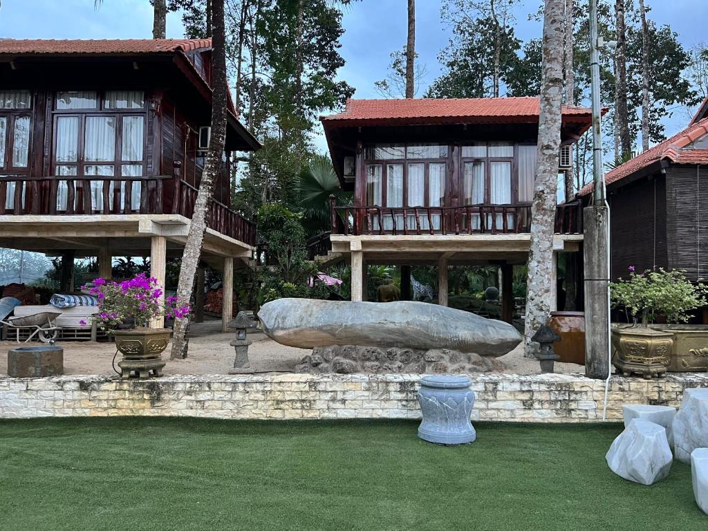 a building with a large rock sitting in a yard at Paradise on the Tree in Cat Tien