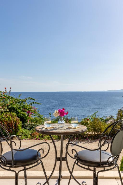 a table and chairs on a patio with the ocean at Costa Smeralda in Syvota