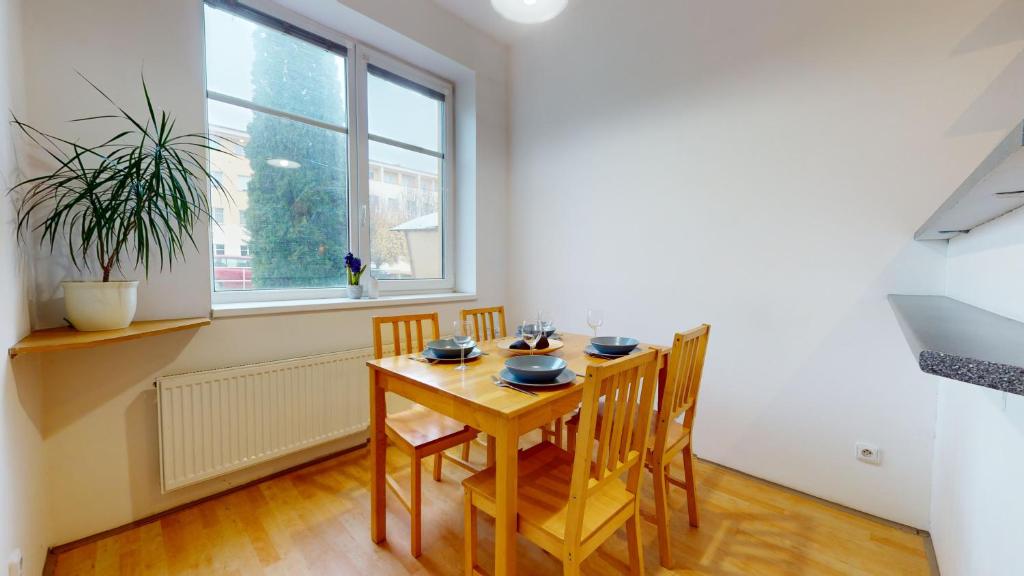 comedor con mesa, sillas y ventana en Apartmán Esser 2 en Milovice