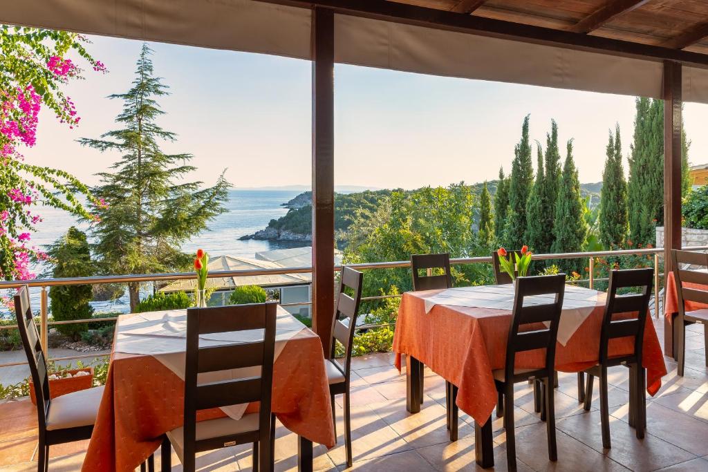 a dining room with a table and chairs on a balcony at Costa Smeralda in Syvota
