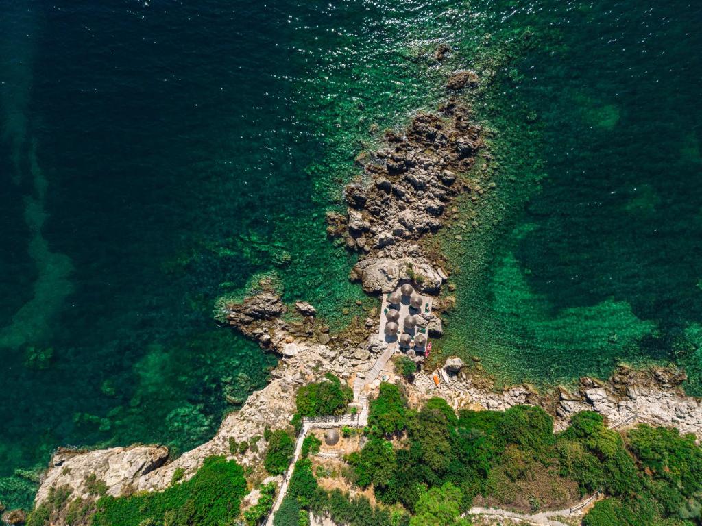 an aerial view of a rocky island in the ocean at Costa Smeralda in Syvota