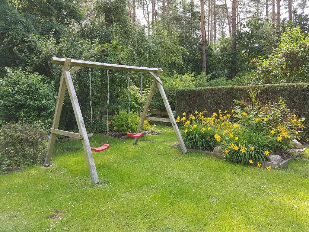 a swing in the grass in a garden at Ferienwohnung Inge Grahl in Lenz