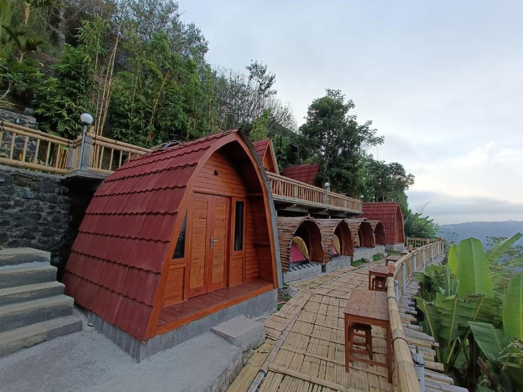 金塔馬尼的住宿－The Panorama Batur Camp，一座有红色屋顶和桥梁的建筑