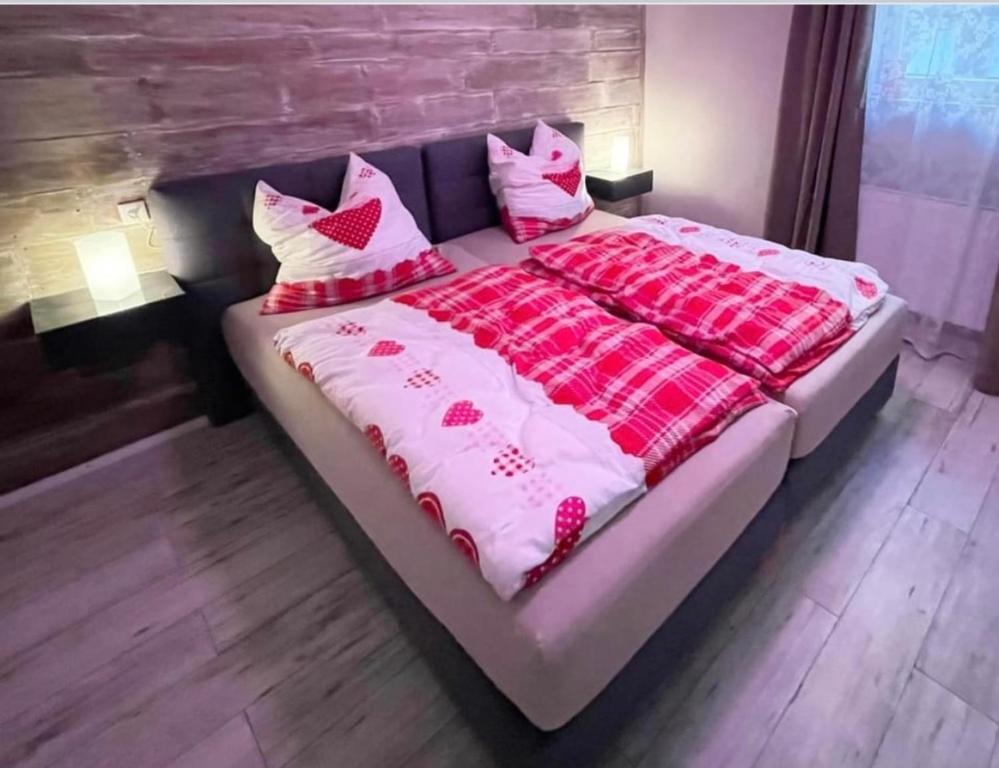 een groot bed met roze en witte dekens en kussens bij Ferienwohnung mit WiFi und 2 Schlafzimmern - b45533 in Ipsheim