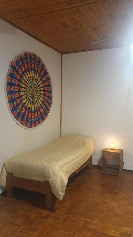 1 dormitorio con 1 cama y reloj en la pared en Verde Parra en Godoy Cruz