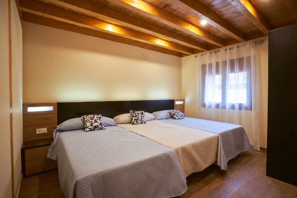 AmuscoにあるCasa Rural Nueve Villasのベッドルーム1室(ベッド2台、窓付)