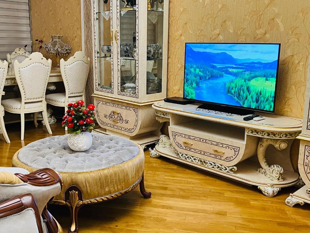 sala de estar con mesa y ordenador portátil en Ganclik apartment by Baku housing en Bakú