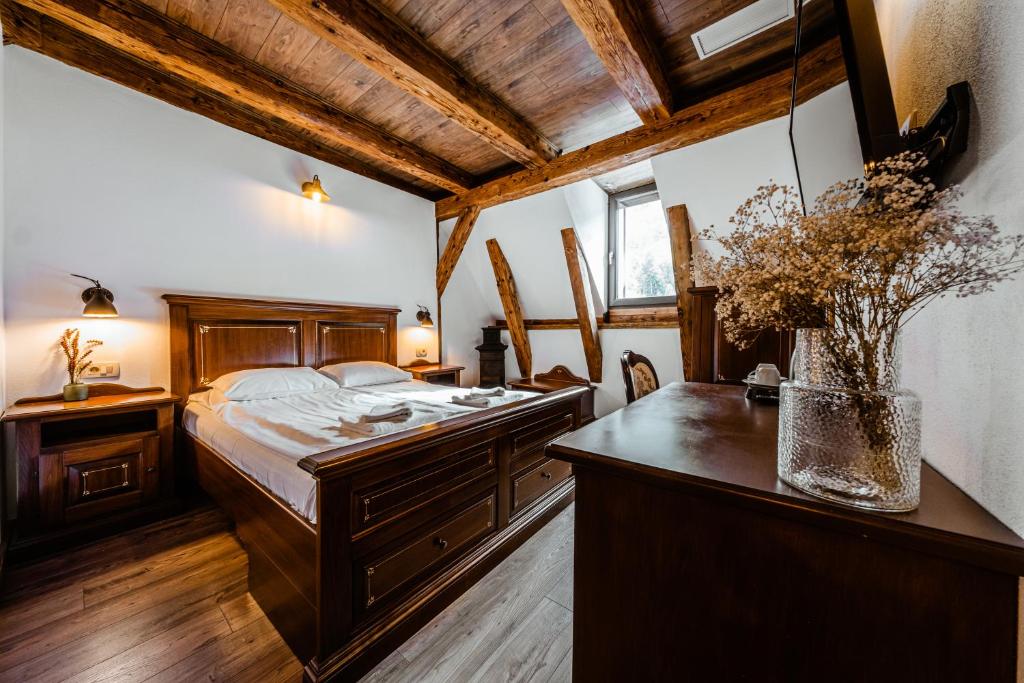 um quarto com uma cama e uma secretária com um vaso em CASA CHITIC - HOTEL & RESTAURANT- Str Nicolae Balcescu 13 em Brasov