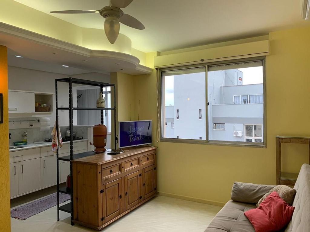 uma sala de estar com um sofá, uma televisão e uma janela em Loft completo, Centro Historico 706 em Porto Alegre