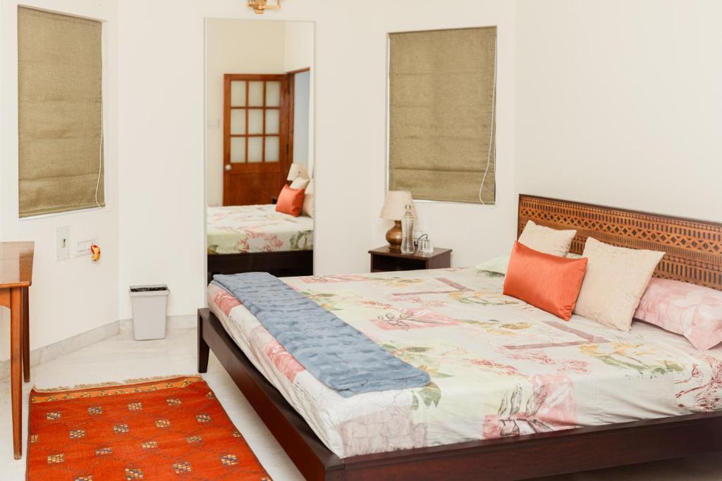 sypialnia z dużym łóżkiem z pomarańczowymi poduszkami w obiekcie Luho 41 Penthouse w mieście Bengaluru