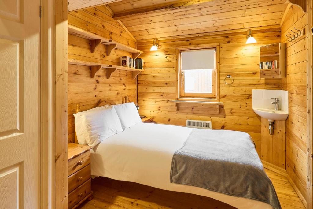 a bedroom with a bed and a sink in a wooden room at Host & Stay - Astoria in Broadstairs