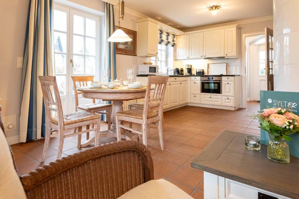 a kitchen with a table and chairs in a kitchen at LH Isernhagenhof, App 1 in Wenningstedt