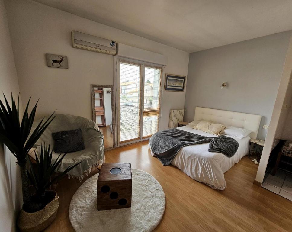 a bedroom with a bed and a couch and a table at Villa Mars YourHostHelper in Narbonne