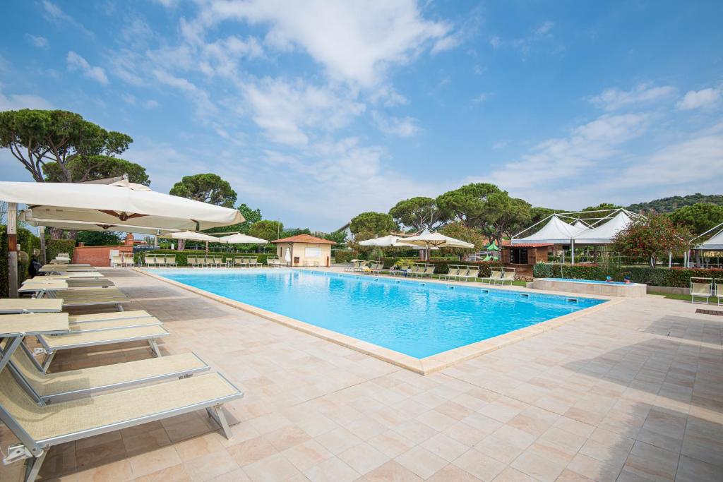 a swimming pool with lounge chairs and umbrellas at Resort Capalbio in Capalbio