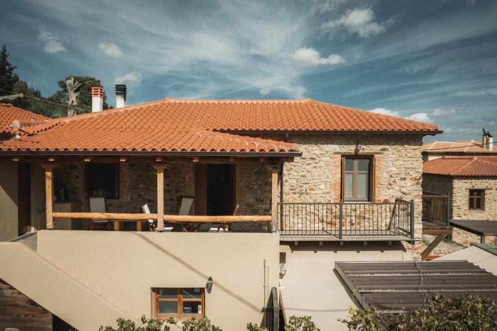 a house with a tile roof and a balcony at Acropolis Mystra Guesthouse in Mystras