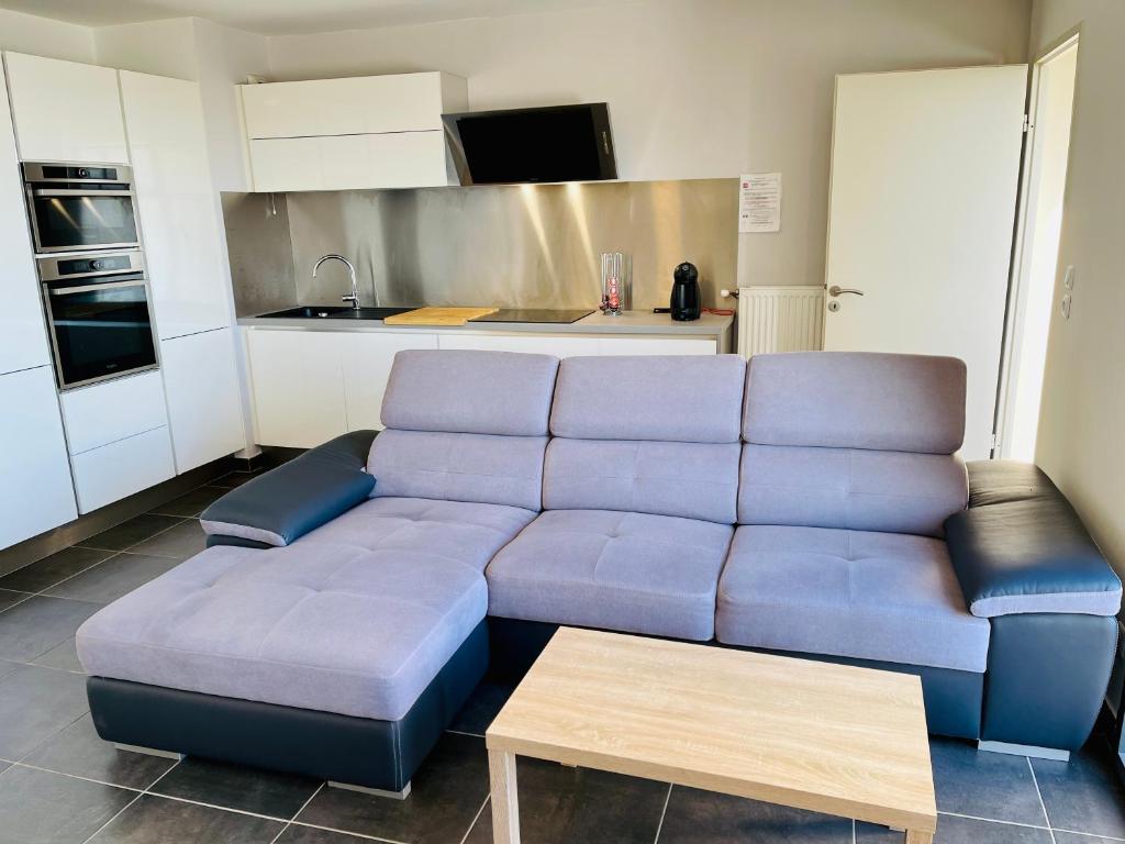 a living room with a blue couch in a kitchen at T2 récent 45m2, Parking inclus, Clim in Aix-en-Provence