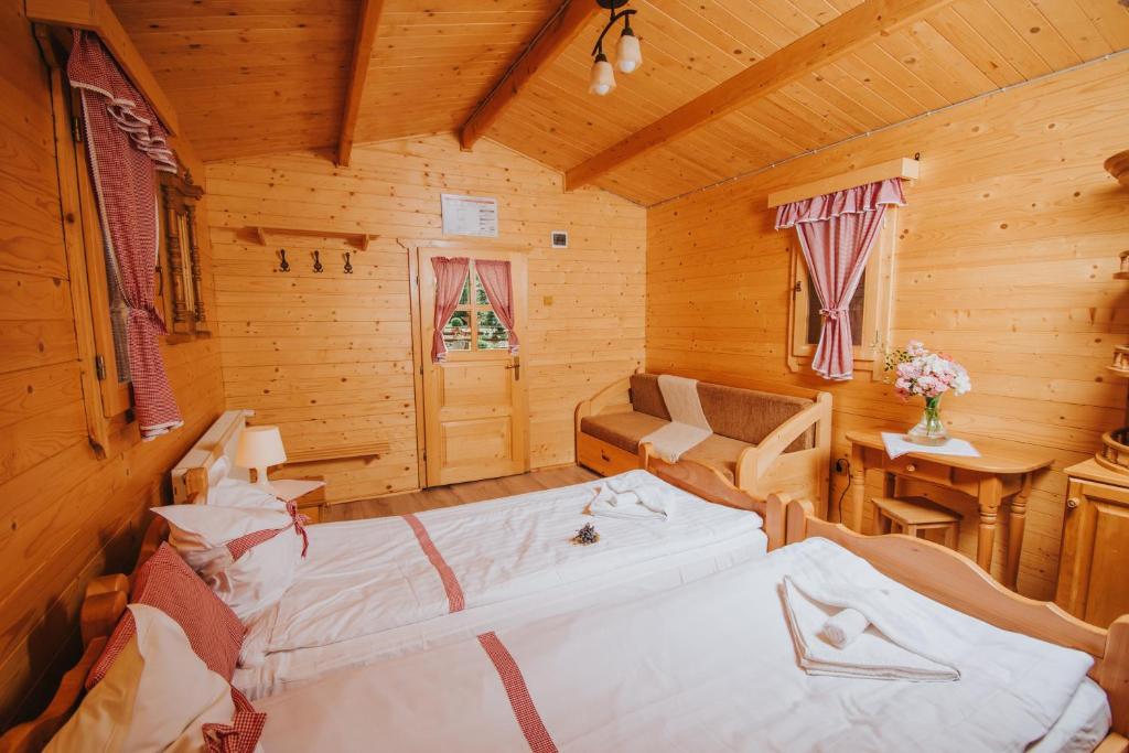 Habitación con 2 camas en una cabaña de madera en Vidra Park, en Sicasău