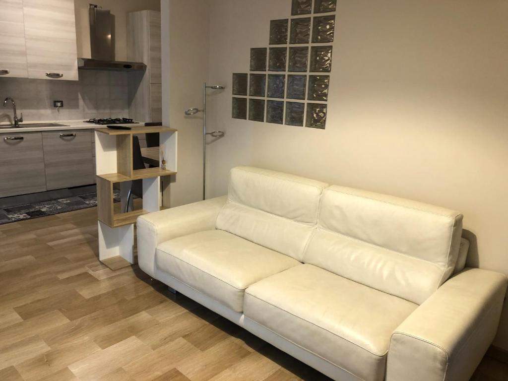 a white couch in a living room with a kitchen at CINI Infinity HOUSE in Cinisello Balsamo