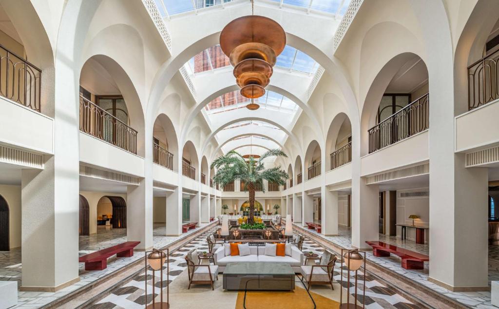 a large building with a vaulted ceiling and a lobby at La Festa Phu Quoc, Curio Collection By Hilton in Phu Quoc