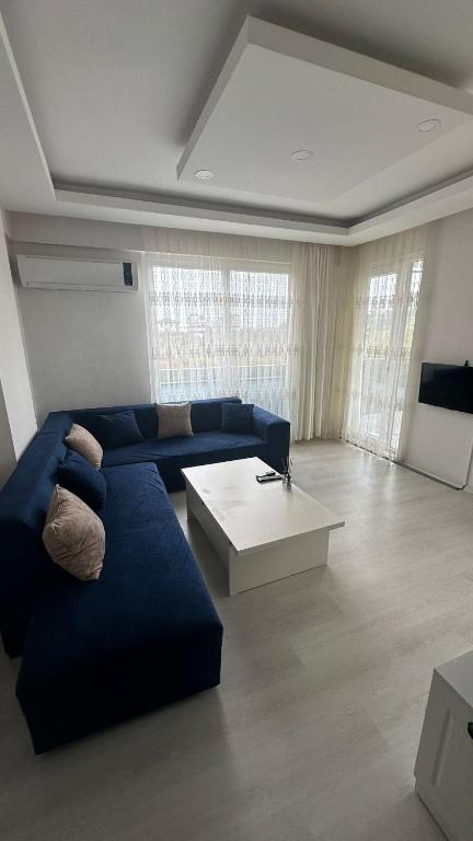 sala de estar con sofá azul y mesa blanca en BVK, en Muğla
