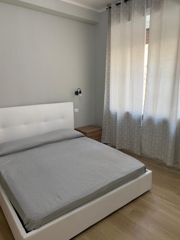 um quarto branco com uma cama branca e uma janela em GRAMSCI 2 rooms em Bolonha