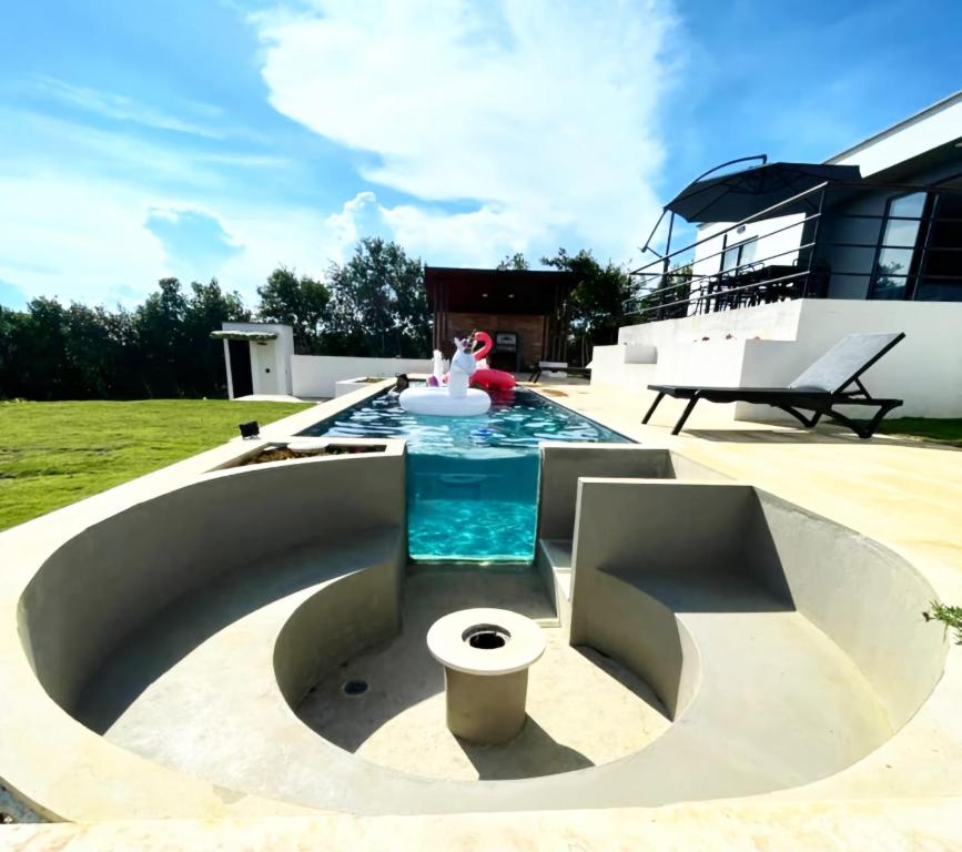 una piscina con un cisne en medio de una casa en Hermosa Villa con piscina, en Los Santos