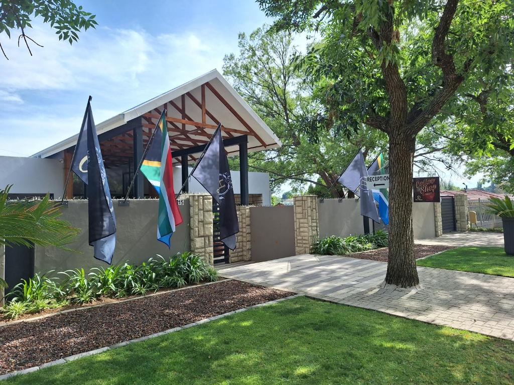 a building with flags in a yard at The Hank Guesthouse Pty Ltd in Bethlehem