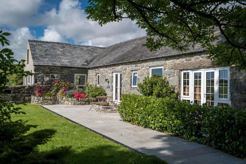a stone house with a garden in front of it at Stabal-Byrdir in Dyffryn