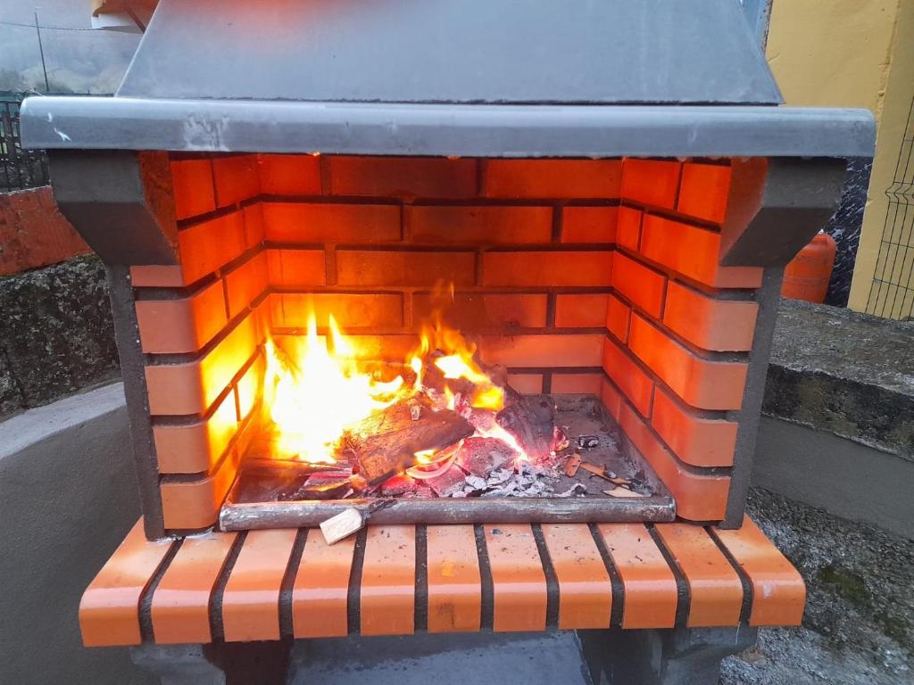 a brick oven with a fire in it at Mediavilla in Aller