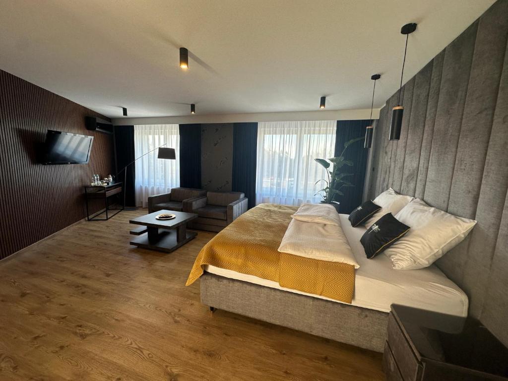 a bedroom with a large bed and a living room at Platinum in Budzyń