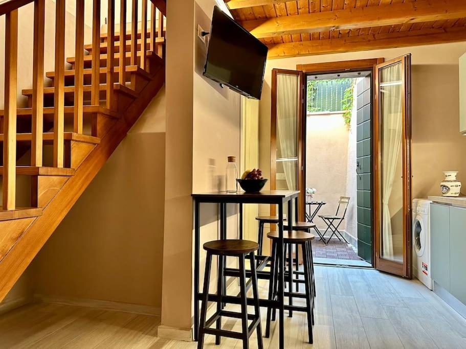 a kitchen with a bar with stools and a staircase at Incantevole Casetta Veneziana in Venice