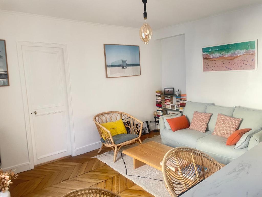ein Wohnzimmer mit einem Sofa und Stühlen in der Unterkunft Au pied de Montmartre in Paris