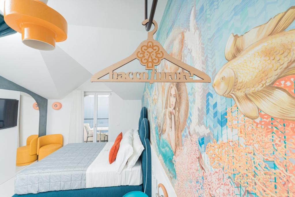 Cette chambre dispose d'un lit et d'une peinture murale. dans l'établissement Albergo Dipinto BaccoFurore, à Furore