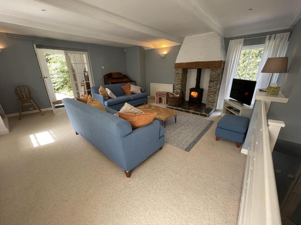 a living room with a blue couch and a fireplace at Crugsillick Court in Veryan