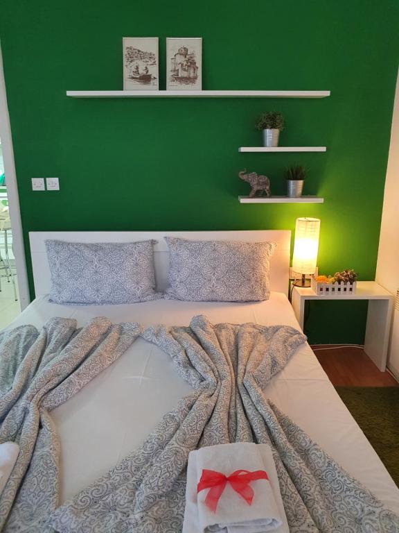 a bedroom with a large bed with a green wall at Apartments Nela in Ohrid