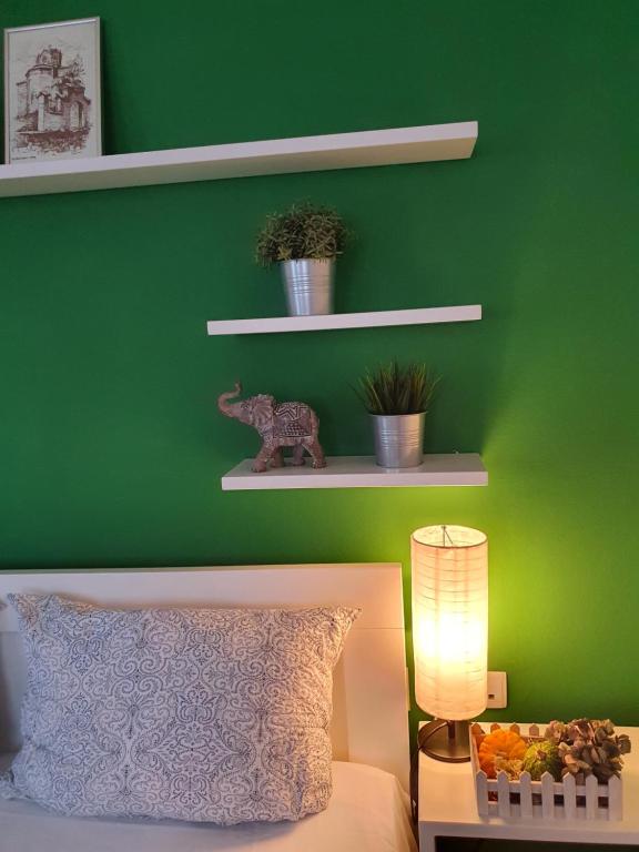 um quarto verde com uma cama e uma parede verde em Apartments Nela em Ohrid
