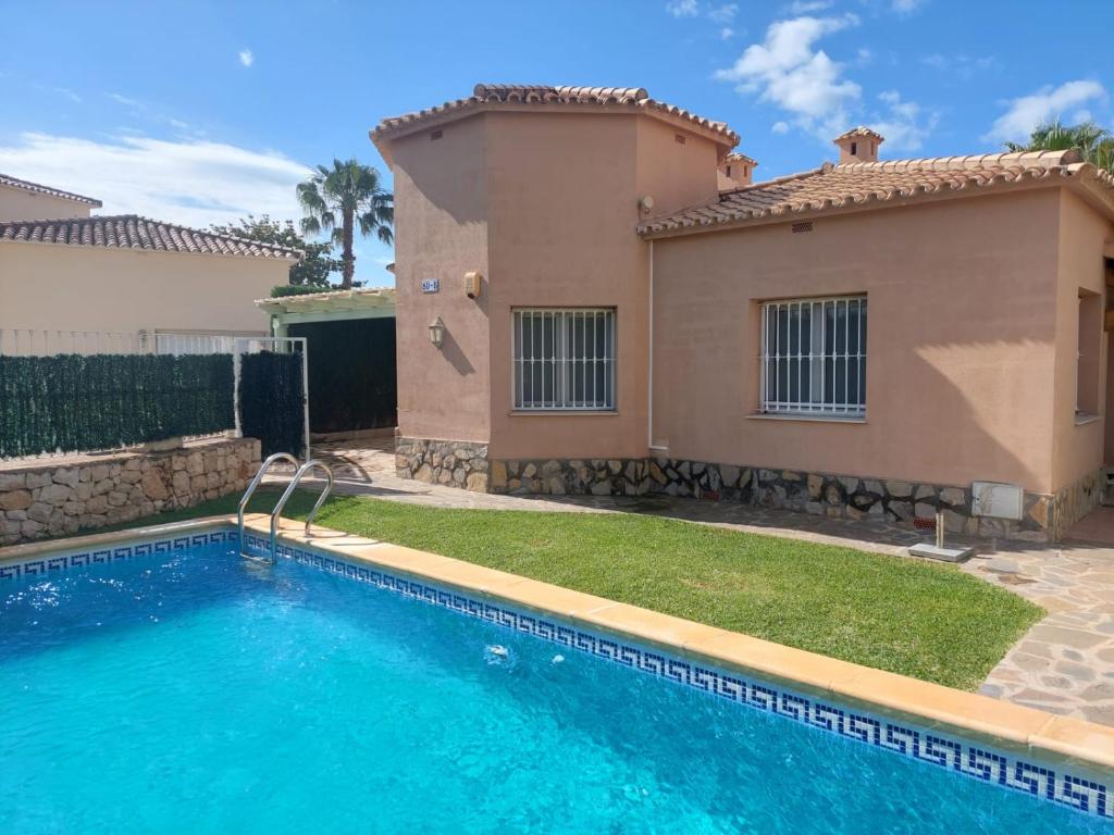 eine Villa mit einem Pool vor einem Haus in der Unterkunft Golf & Playa II in Oliva