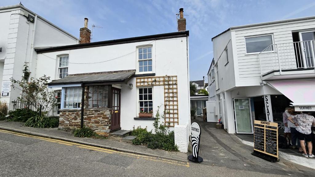 un edificio bianco sul lato di una strada di Hillside Cottage a Porthscatho