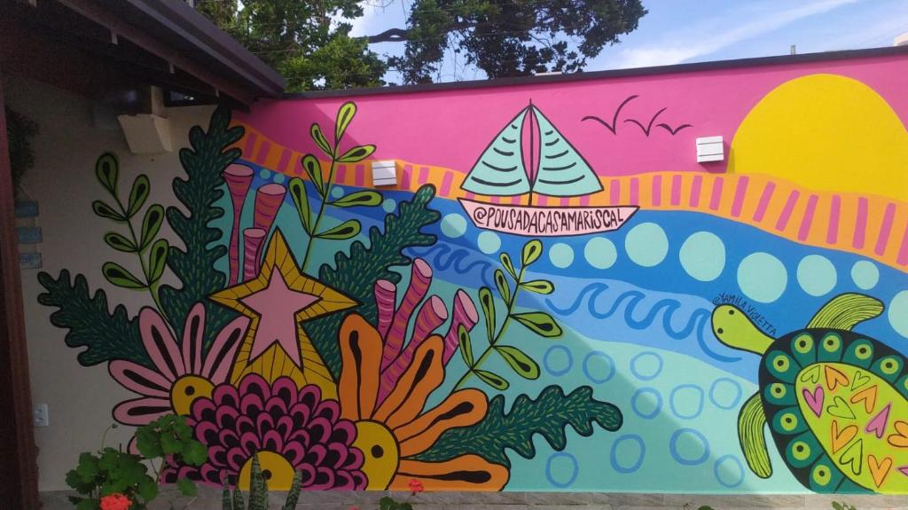 a wall with a colorful mural on it at Pousada Casa Mariscal in Bombinhas