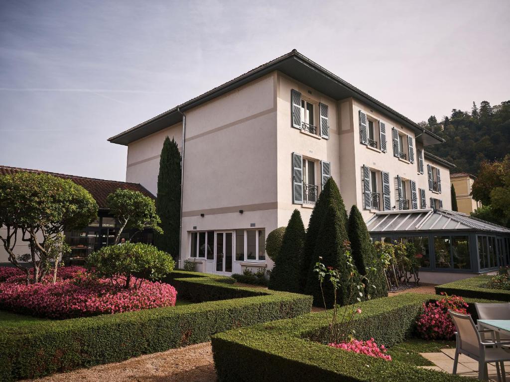 Un gran edificio blanco con un jardín delante. en La Pyramide - Maison Henriroux, en Vienne