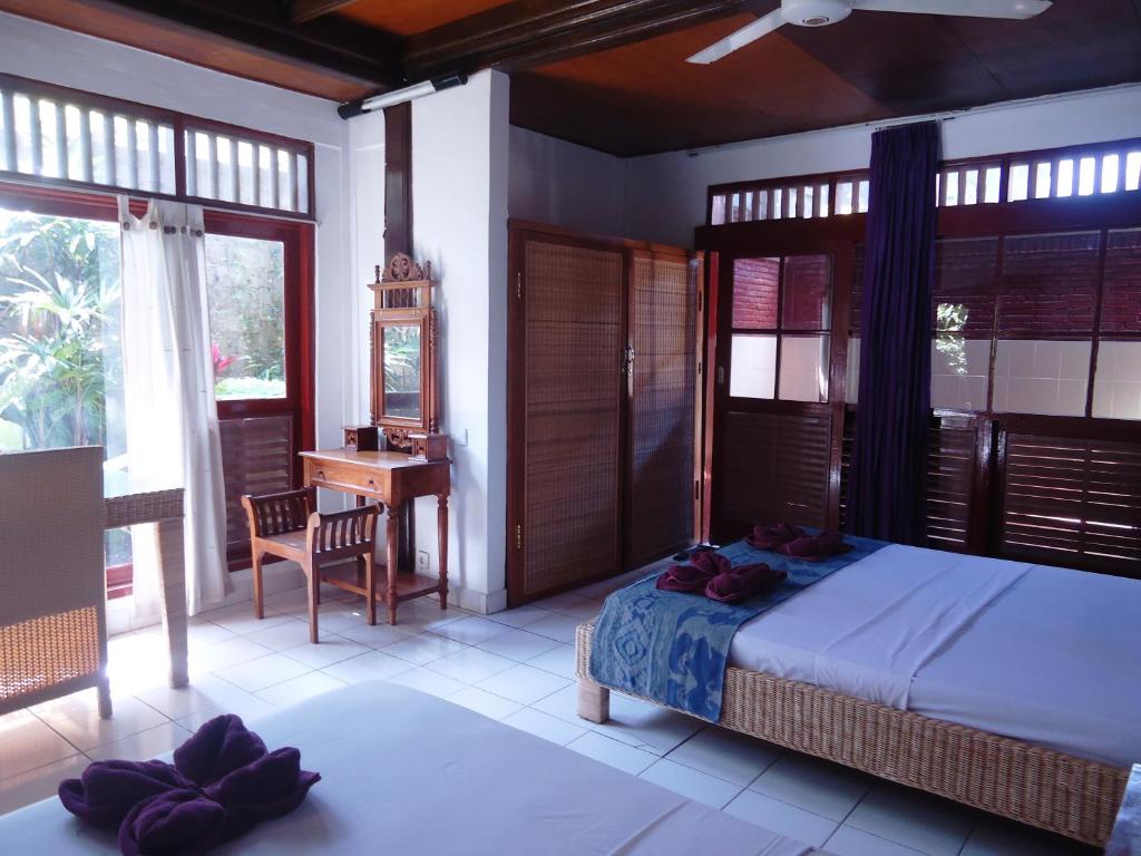 Un dormitorio con una cama y un escritorio en una habitación. en Argasoka Bungalows, en Ubud
