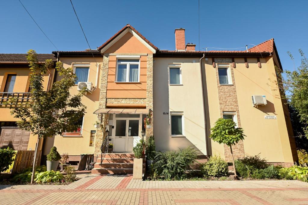 a large yellow house on a street at BellaVista 1 Apartman in Eger