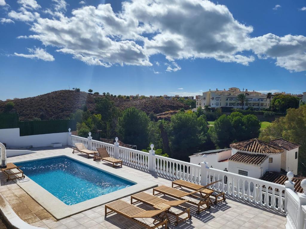 a balcony with a swimming pool and lounge chairs at Chalet Antonio in Benalmádena