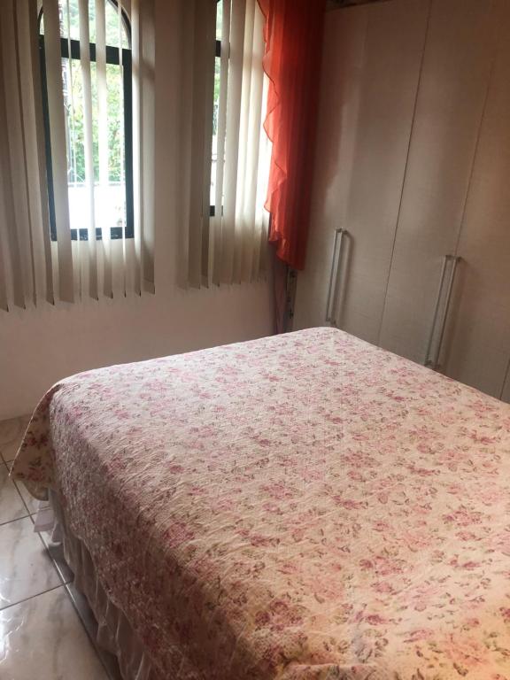 una camera da letto con un letto con una coperta rossa sopra di Casa temporada com Piscina a Governador Celso Ramos